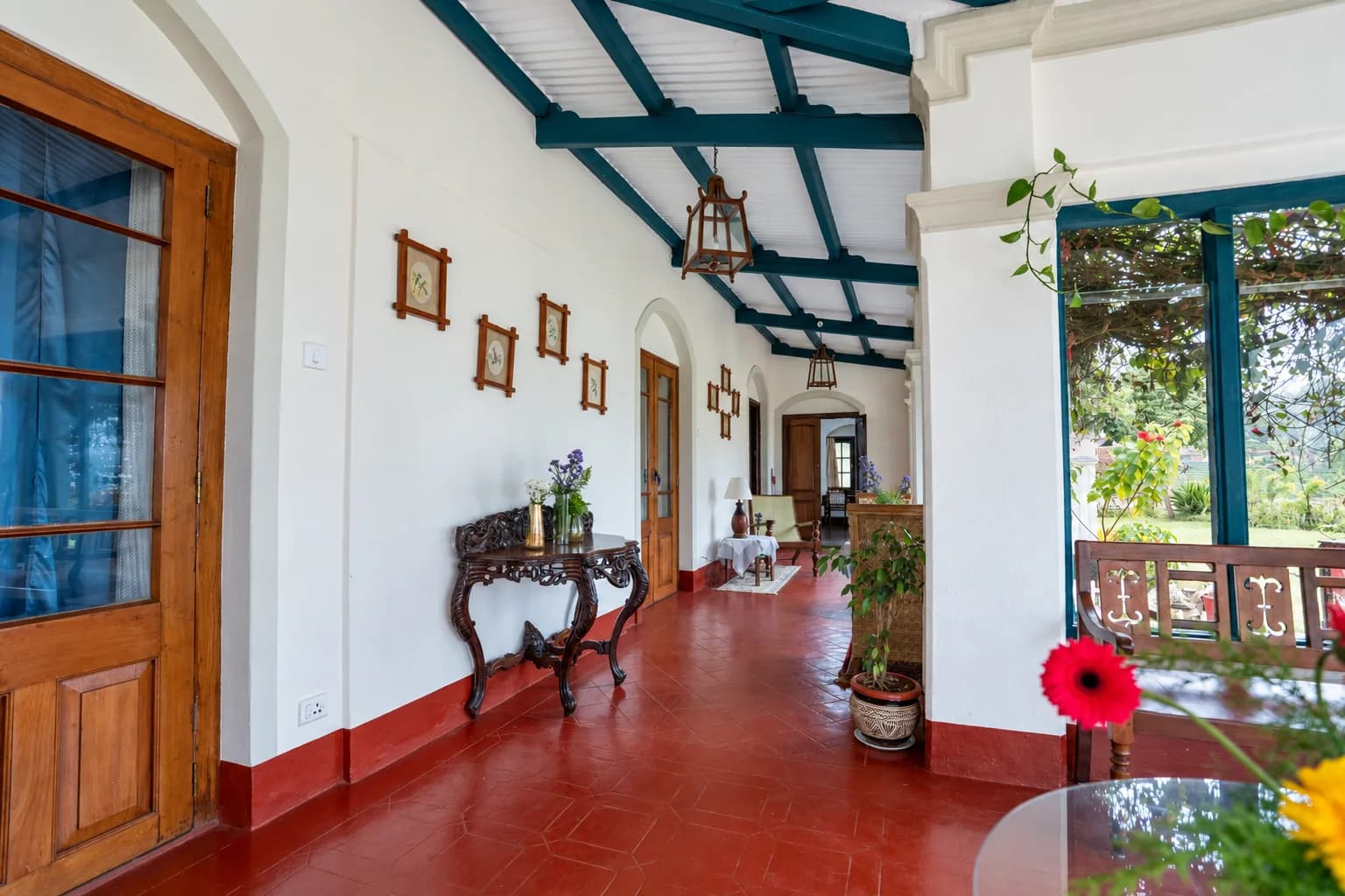 The corridor behind the veranda, red floor and blue-framed doors