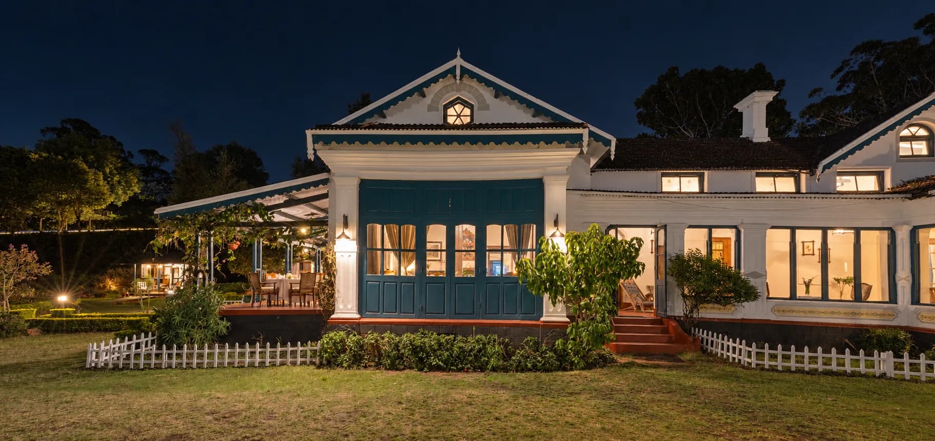 The house at dusk, every window glowing