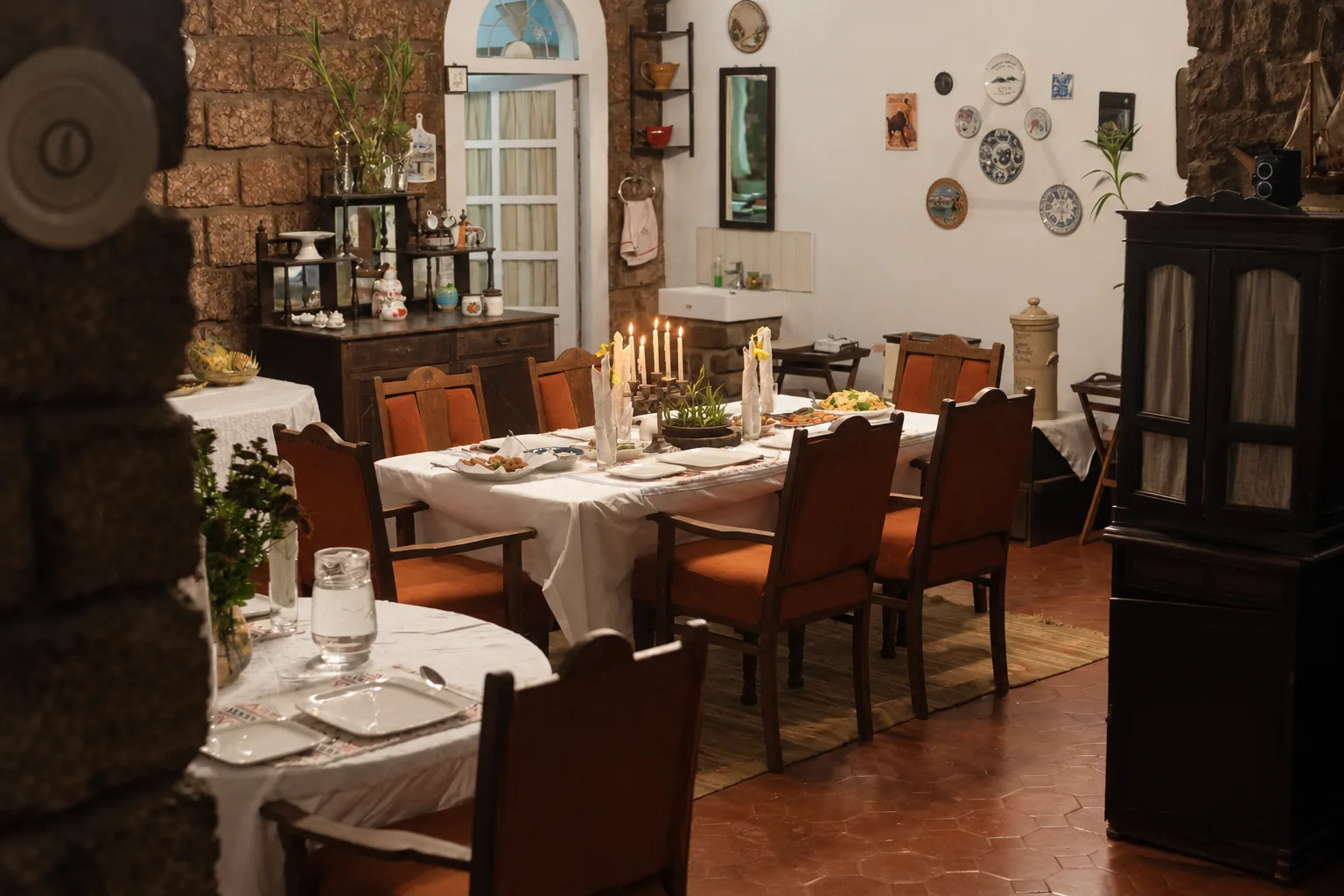 The dining room, laid for a meal against a stone wall