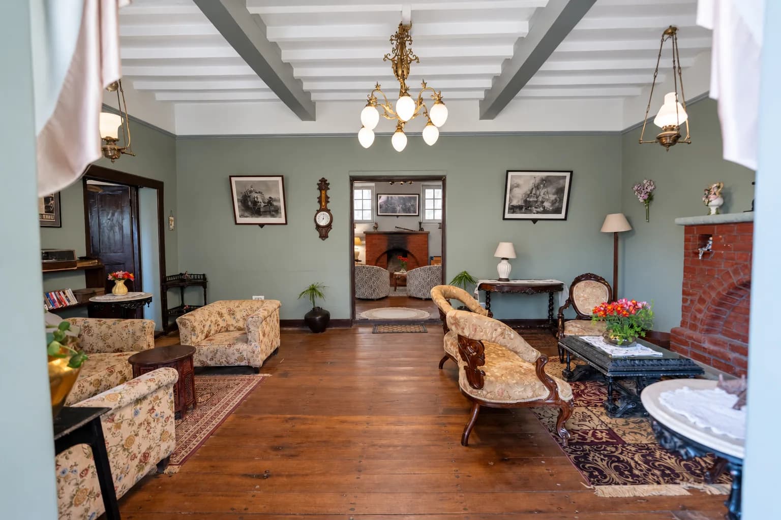 The drawing room under its beamed ceiling and chandelier