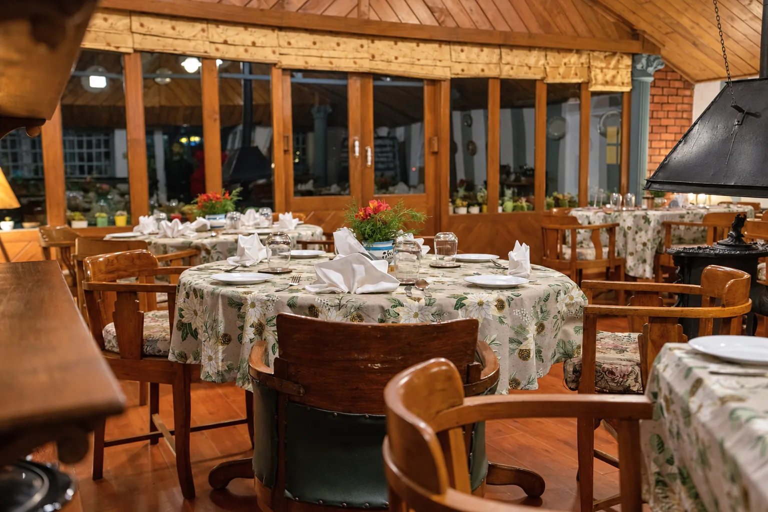 The dining room, glazed along one side, its tables laid