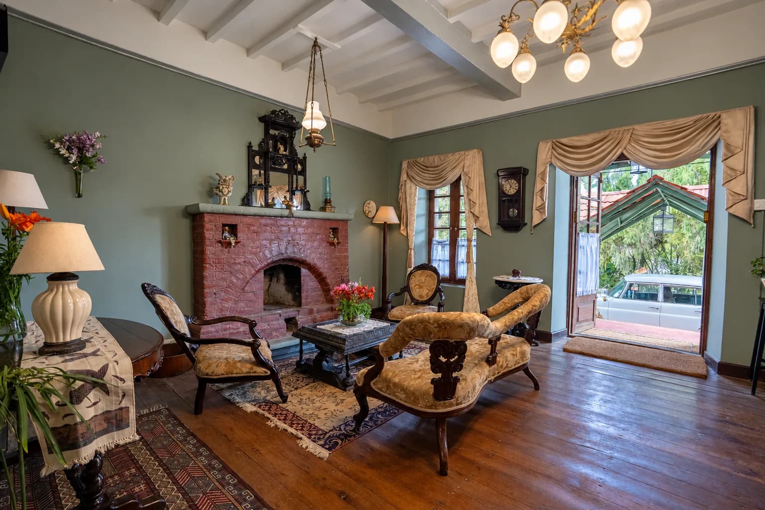 The sitting-room fireplace, doors open to the garden